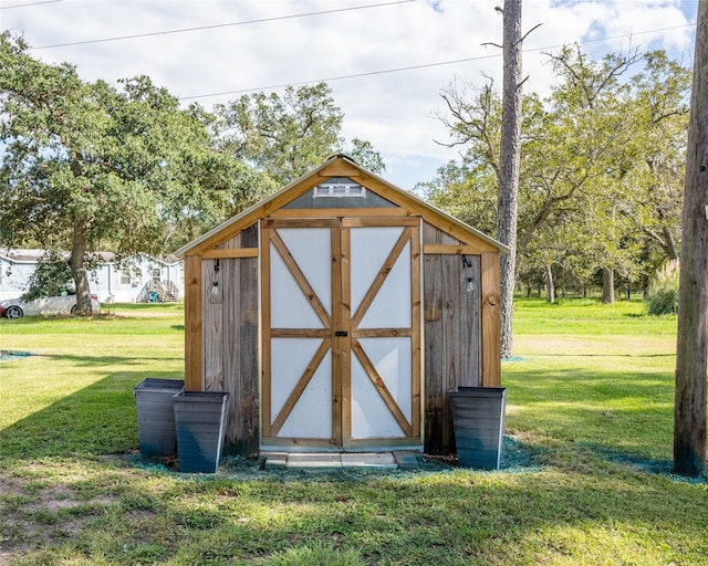 view of outbuilding featuring a lawn