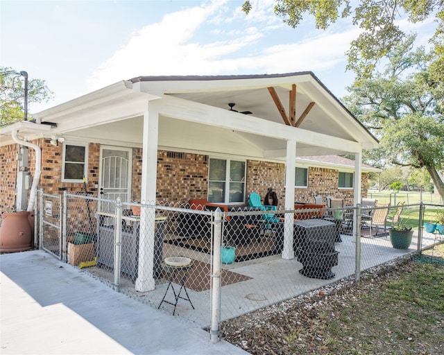 rear view of house with ceiling fan and a patio area