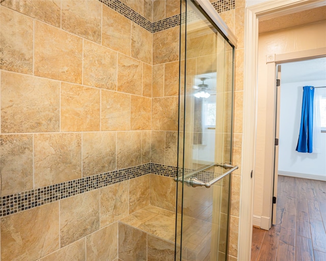 bathroom with wood-type flooring, ceiling fan, and walk in shower