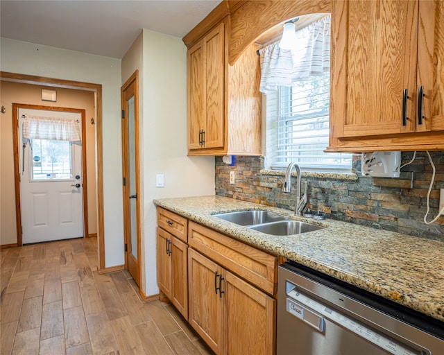 kitchen featuring a wealth of natural light, light hardwood / wood-style floors, stainless steel dishwasher, and sink