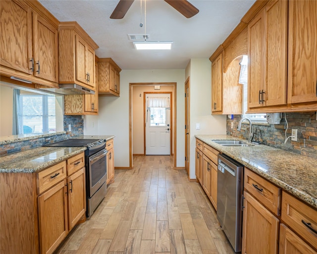 kitchen featuring appliances with stainless steel finishes, light wood-type flooring, sink, and tasteful backsplash