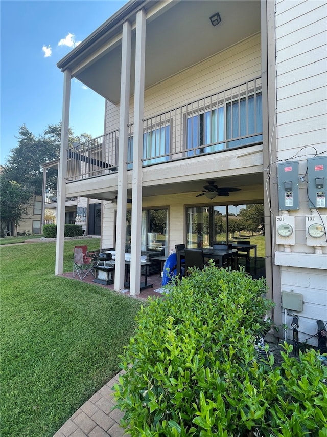 rear view of house with a patio, a yard, and ceiling fan