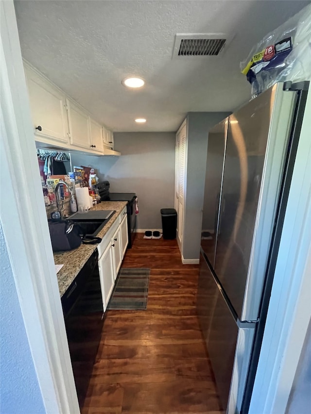 kitchen featuring black appliances, sink, a textured ceiling, white cabinets, and dark wood-type flooring