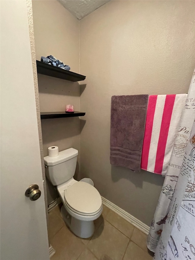 bathroom with toilet and tile patterned floors