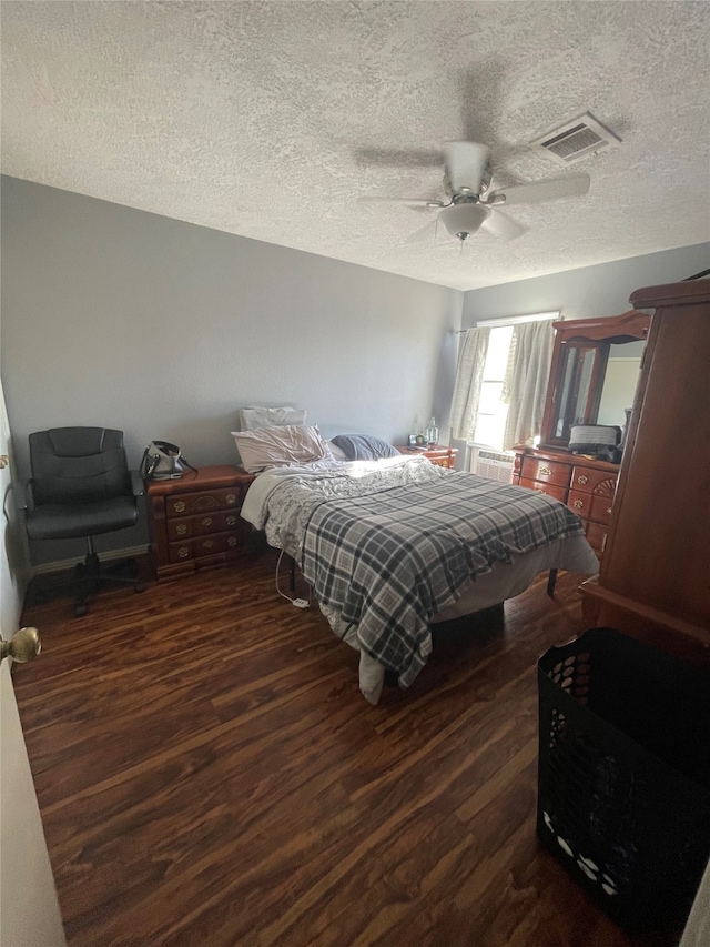 bedroom featuring a textured ceiling, dark hardwood / wood-style floors, and ceiling fan