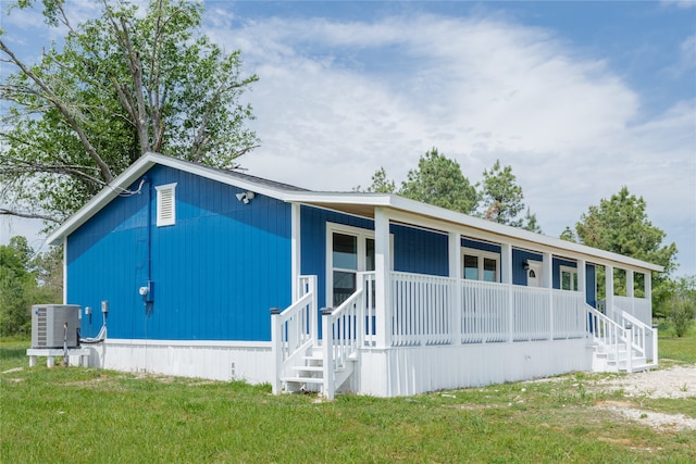 manufactured / mobile home with a front yard, a porch, and central AC unit