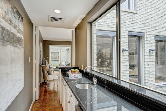 bathroom with vanity, parquet floors, ornamental molding, and a healthy amount of sunlight