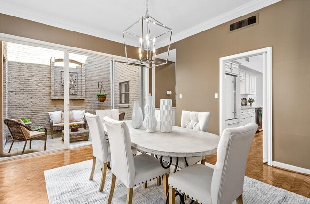 dining area with light parquet floors, ornamental molding, and a notable chandelier