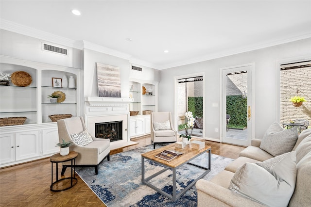 living room featuring built in shelves, ornamental molding, and light parquet floors