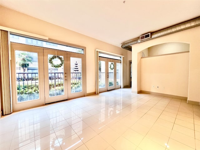 tiled empty room with french doors