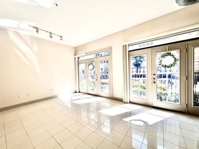 doorway to outside featuring french doors, a healthy amount of sunlight, and light tile patterned floors