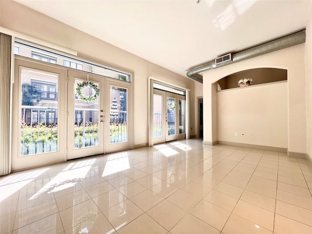 tiled empty room with french doors and plenty of natural light