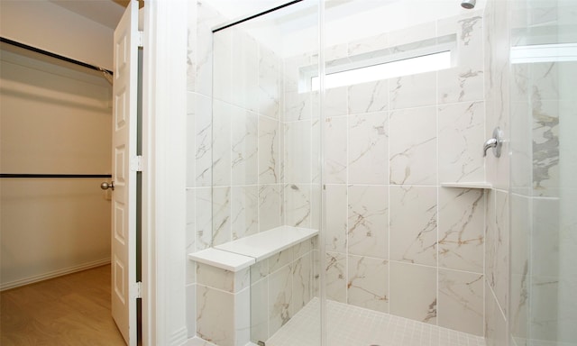 bathroom featuring tiled shower and wood-type flooring