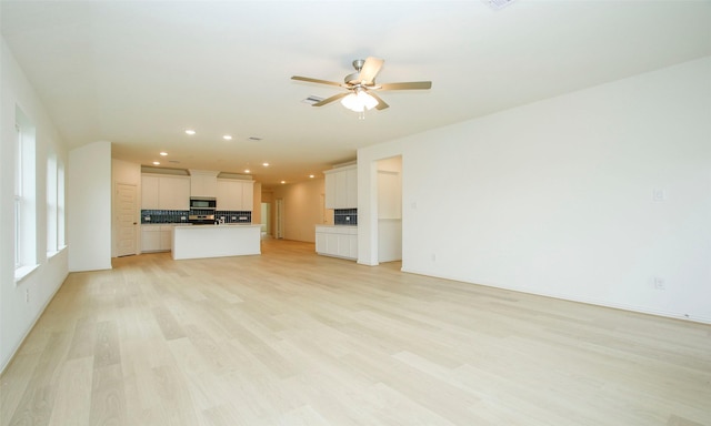 unfurnished living room featuring light hardwood / wood-style flooring and ceiling fan