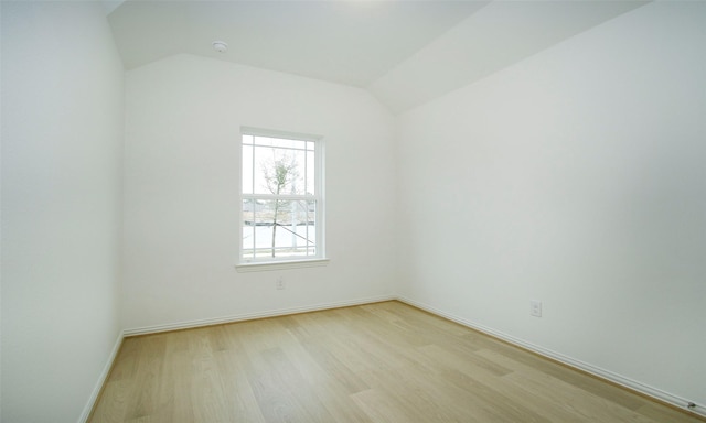 unfurnished room with lofted ceiling and light hardwood / wood-style flooring