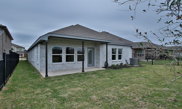 rear view of property featuring a yard, a patio, and central AC