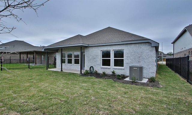 rear view of house with a lawn, a patio area, and cooling unit