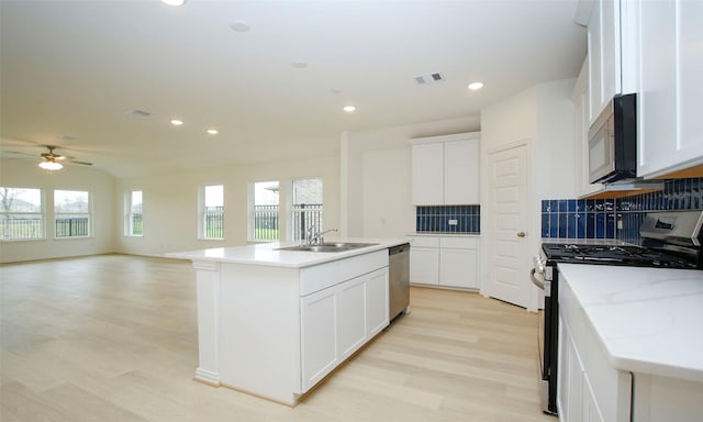 kitchen featuring white cabinets, sink, an island with sink, and appliances with stainless steel finishes