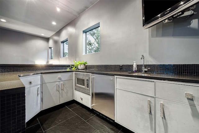 kitchen with white cabinetry, sink, stainless steel appliances, and backsplash