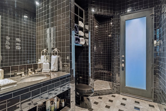 bathroom featuring toilet, a shower with door, vanity, and tile walls