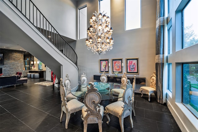 dining area featuring dark tile patterned flooring, a chandelier, and a high ceiling