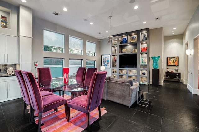 dining area featuring ceiling fan and dark tile patterned flooring