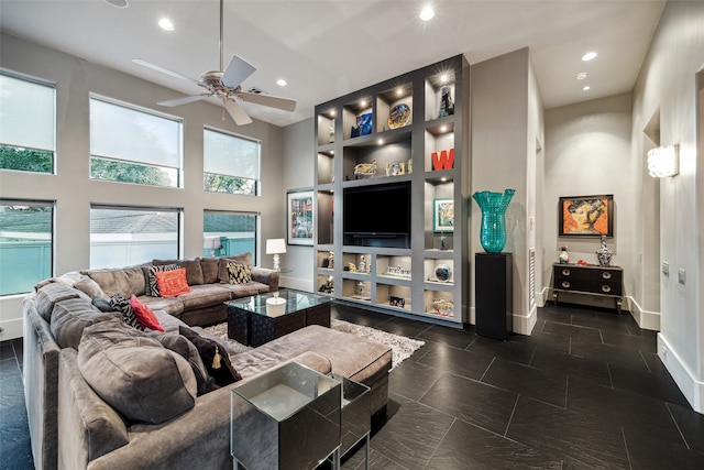 living room featuring a towering ceiling and ceiling fan