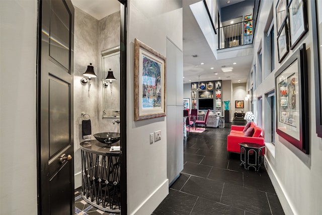 corridor featuring dark tile patterned flooring and sink