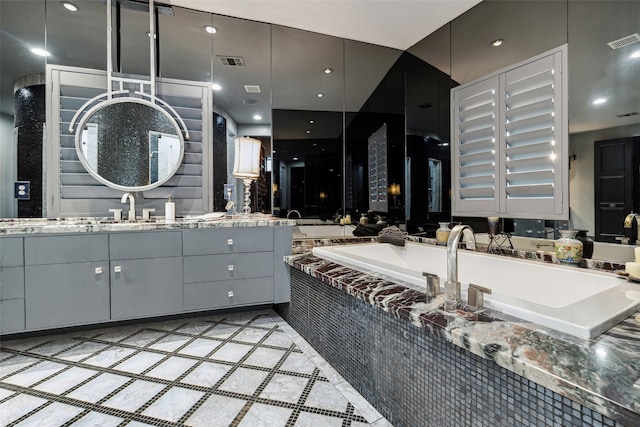 bathroom featuring tiled tub and vanity