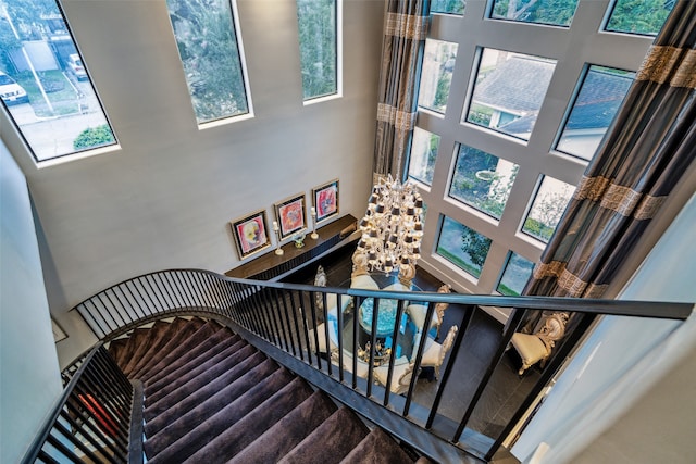 stairs featuring a towering ceiling and a healthy amount of sunlight