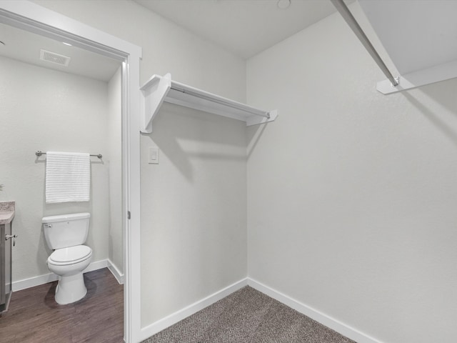 spacious closet with dark wood-type flooring