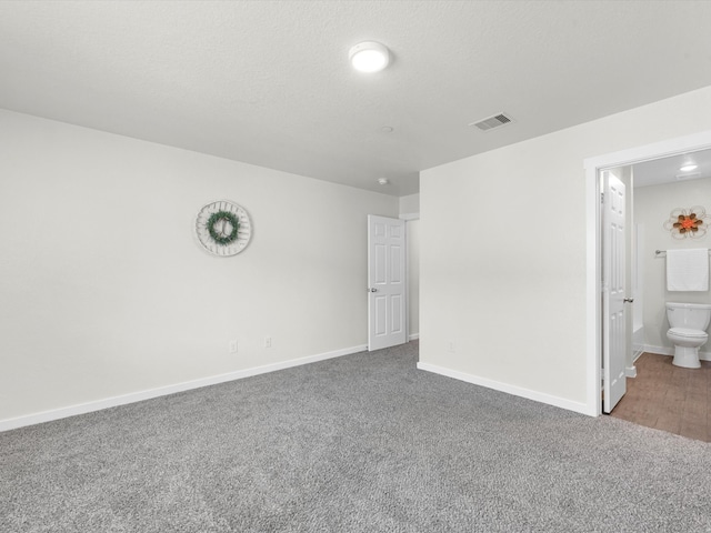 carpeted empty room featuring a textured ceiling