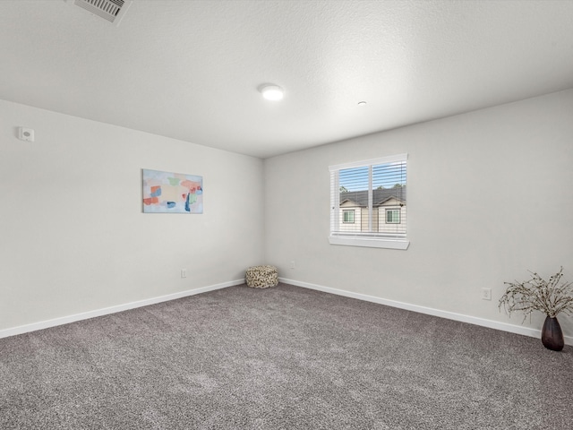 carpeted empty room featuring a textured ceiling