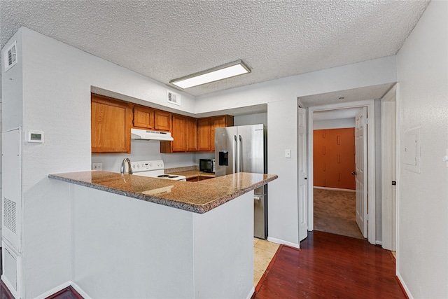 kitchen featuring a textured ceiling, dark hardwood / wood-style floors, stainless steel fridge with ice dispenser, dark stone countertops, and white electric range