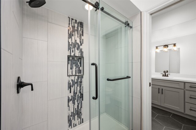 bathroom featuring vanity, tile patterned flooring, and a shower with shower door