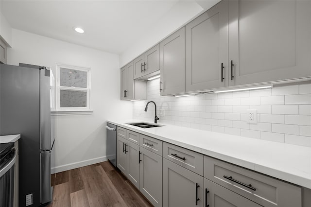 kitchen featuring gray cabinets, appliances with stainless steel finishes, dark hardwood / wood-style floors, and sink