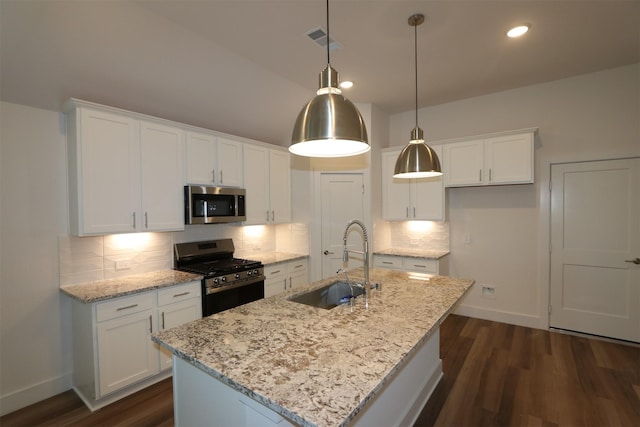 kitchen with visible vents, a sink, stainless steel appliances, white cabinets, and backsplash