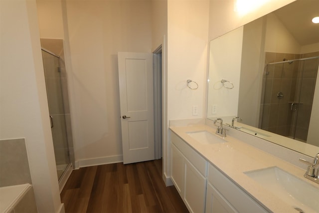 bathroom with a sink, wood finished floors, and a shower stall