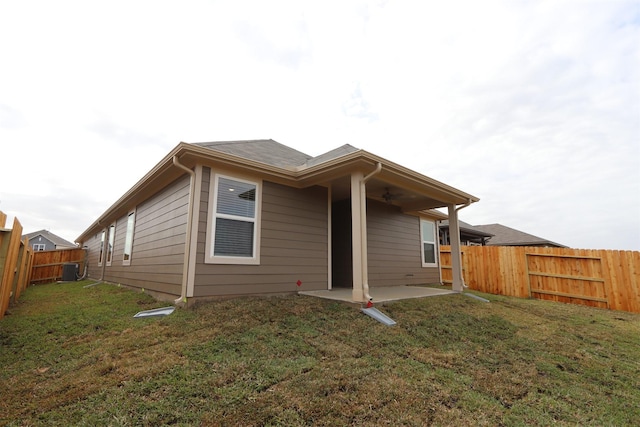 rear view of house featuring a patio, a yard, a fenced backyard, and cooling unit