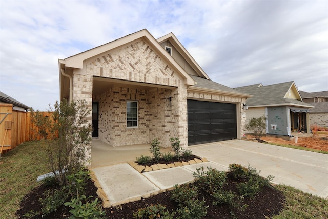 view of front facade with stone siding, fence, concrete driveway, a garage, and brick siding