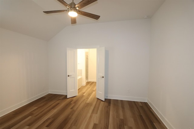 spare room with a ceiling fan, vaulted ceiling, wood finished floors, and baseboards