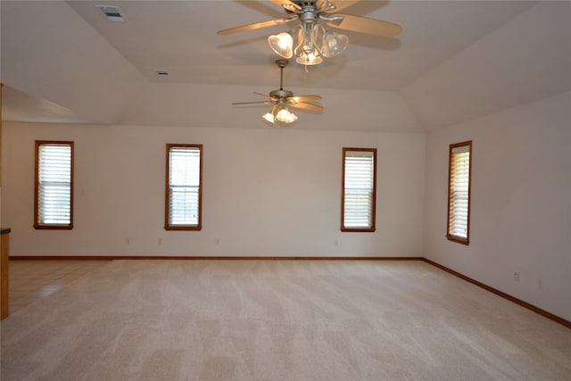 empty room featuring lofted ceiling, ceiling fan, and light colored carpet