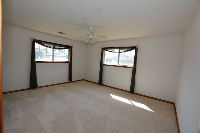 carpeted spare room with ceiling fan