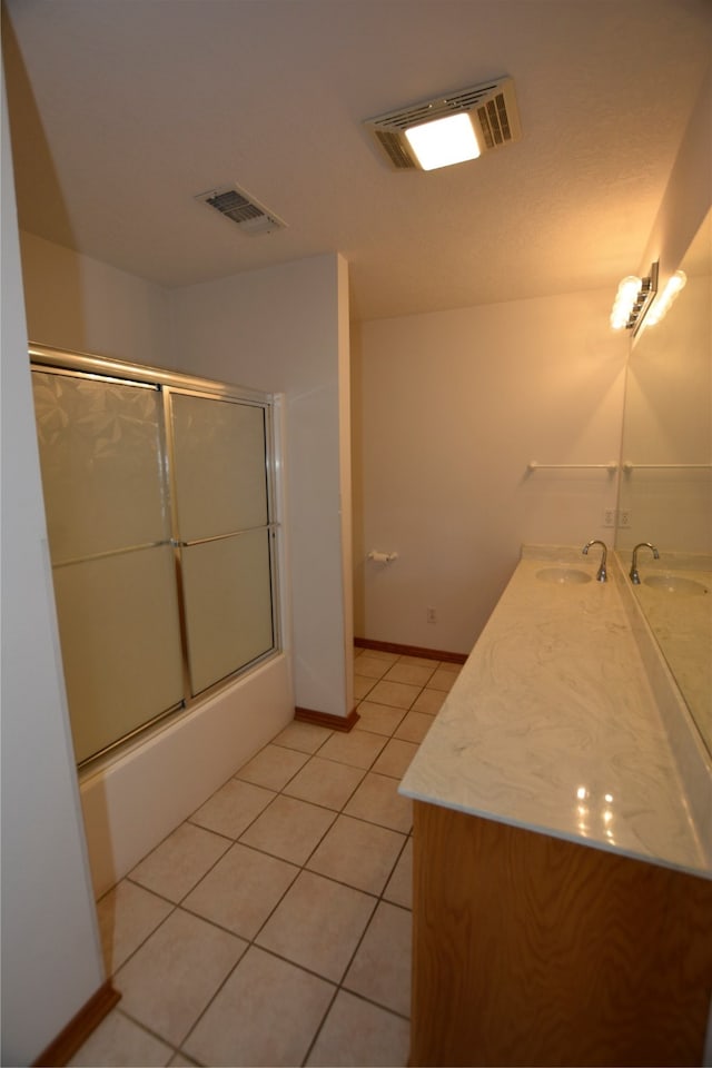 bathroom featuring enclosed tub / shower combo, vanity, and tile patterned floors