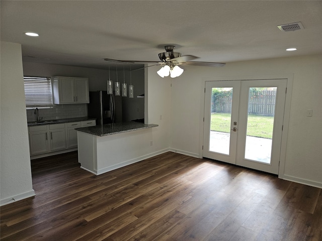 kitchen with dark wood-type flooring, white cabinets, kitchen peninsula, black fridge with ice dispenser, and french doors