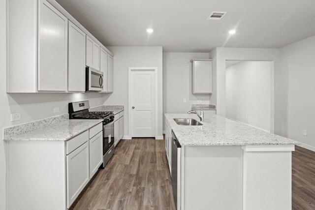 kitchen with sink, stainless steel appliances, white cabinetry, and a center island with sink