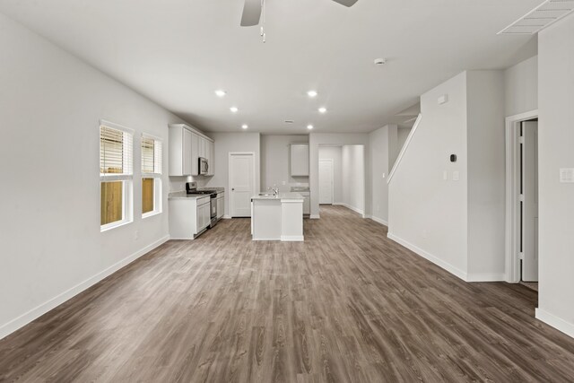 unfurnished living room with hardwood / wood-style flooring and ceiling fan