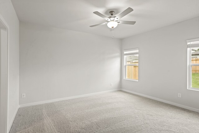 spare room featuring a healthy amount of sunlight, carpet flooring, and ceiling fan