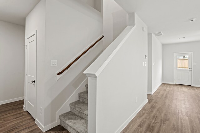 stairs featuring hardwood / wood-style floors