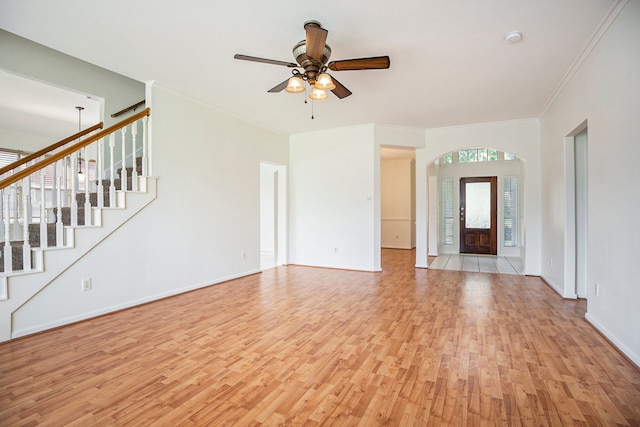 unfurnished living room featuring light hardwood / wood-style floors, ceiling fan, and crown molding